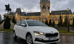 Mașină de închiriat Škoda Scala albă, fotografiată în fața Palatului Culturii din Iași, la apus.
