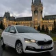 Mașină de închiriat Škoda Scala albă, fotografiată în fața Palatului Culturii din Iași, la apus.